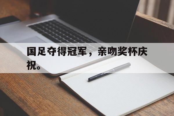国足夺得冠军，亲吻奖杯庆祝。